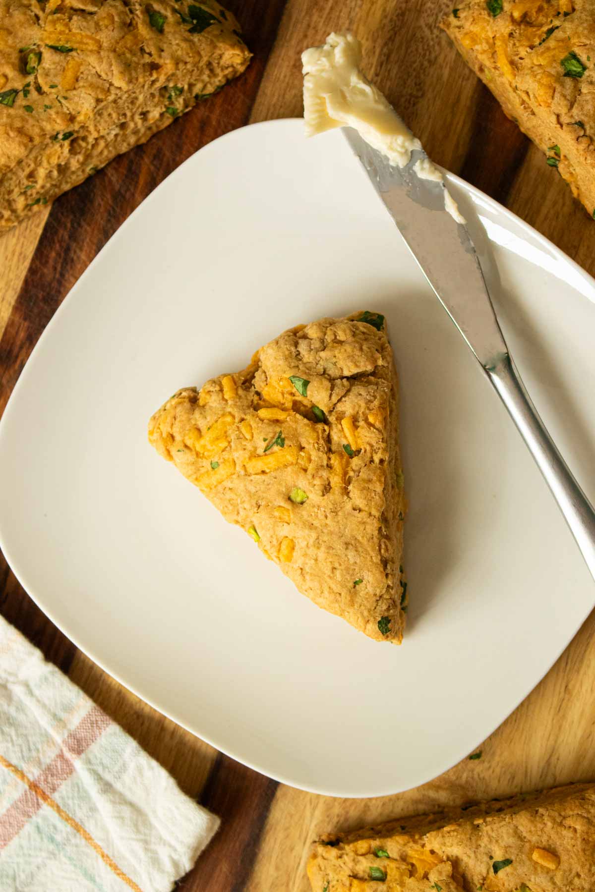 savory vegan scone on a plate with a butter knife