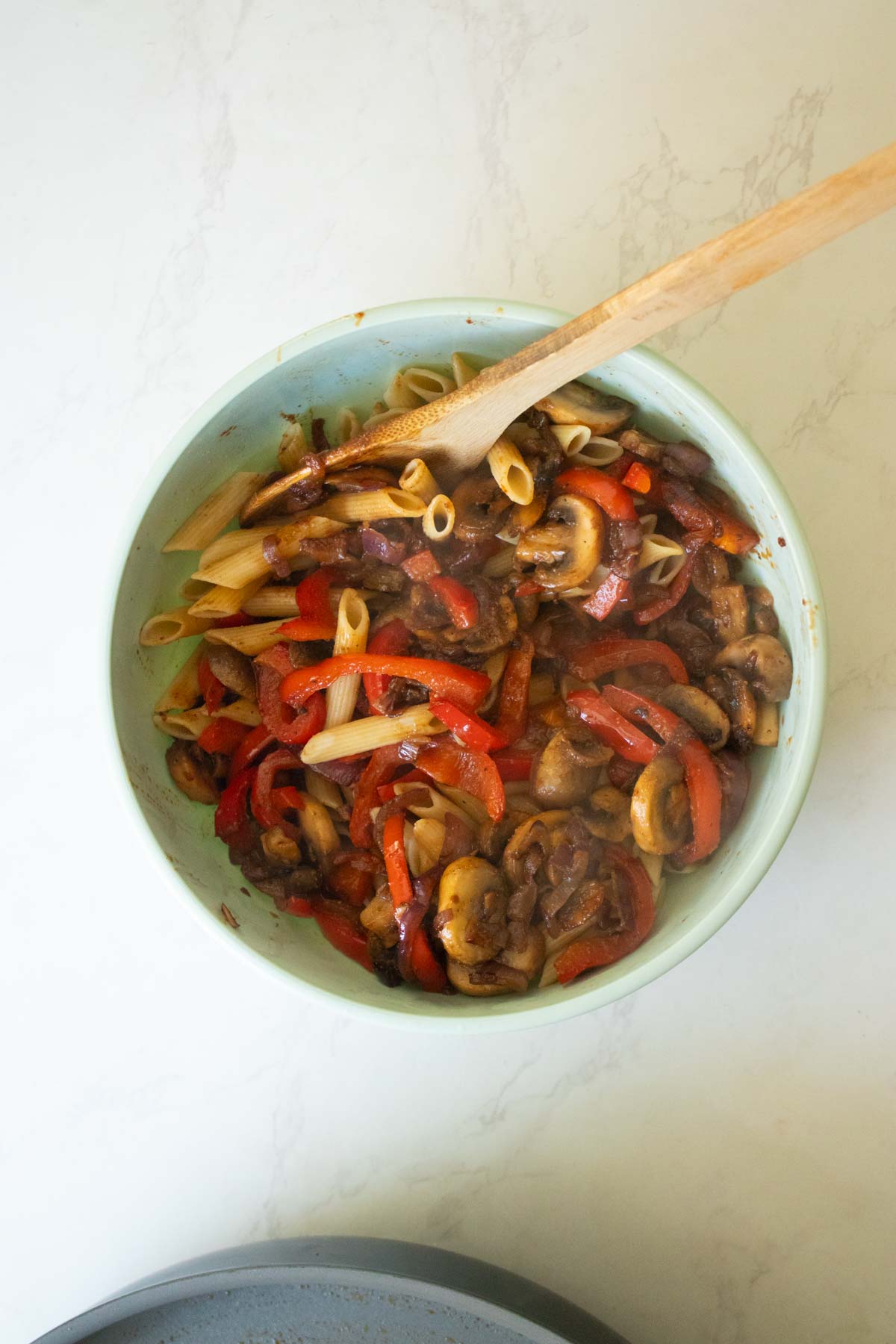 adding veggies to the pasta