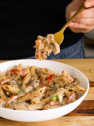 fork taking a bite of vegan Philly cheesesteak pasta