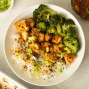 bowl of sheet pan honey garlic tofu with broccoli and rice after garnishing