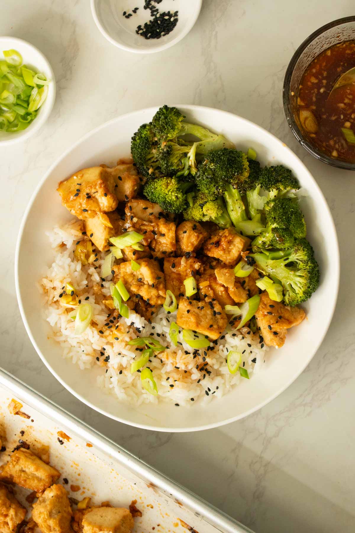 bowl of sheet pan honey garlic tofu with broccoli and rice after garnishing
