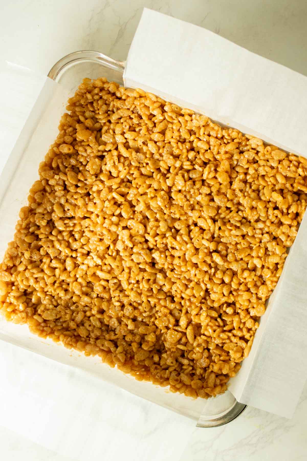 peanut butter rice crispy treats in the pan before chilling