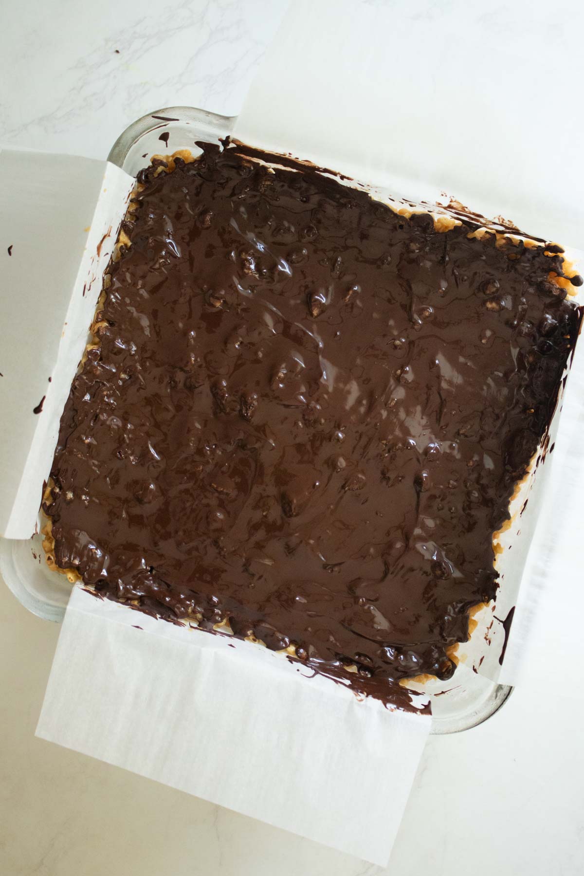 chocolate peanut butter rice crispy treats in the pan before chilling and slicing