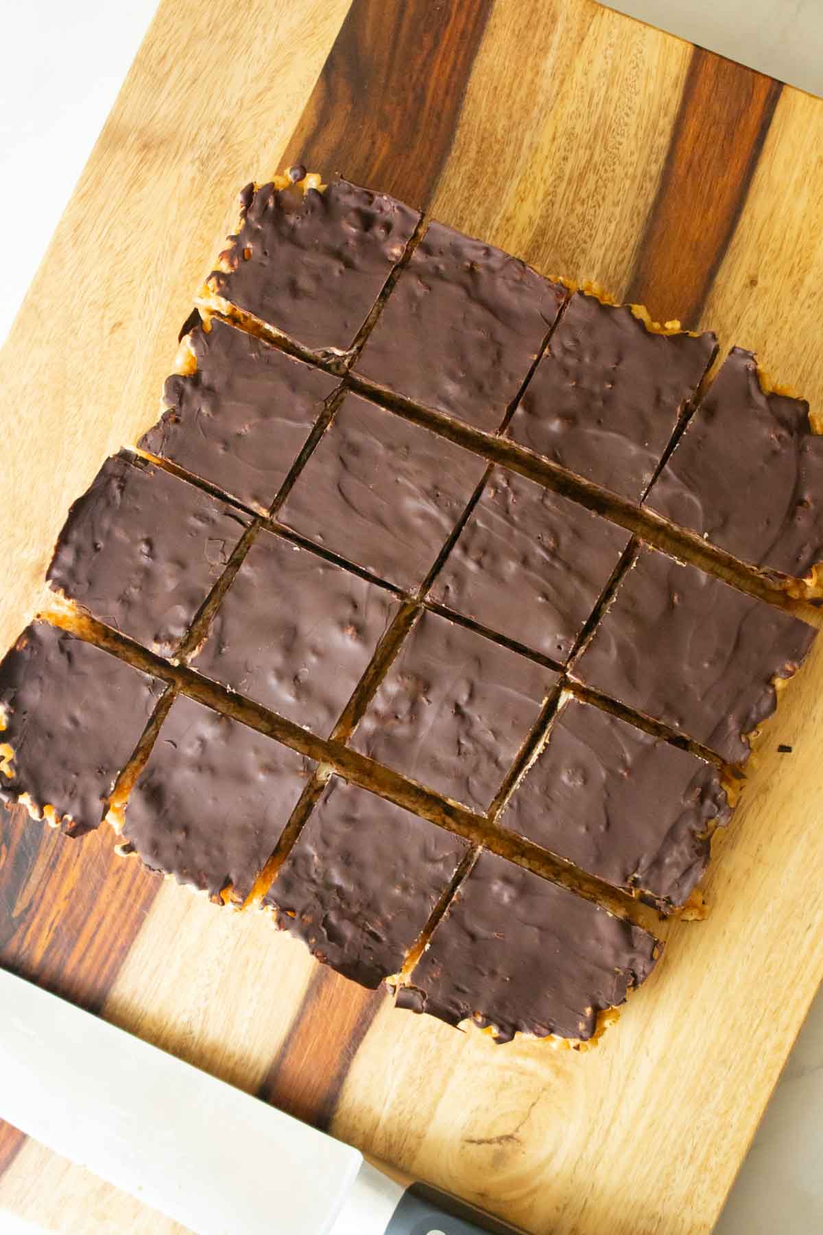 chocolate peanut butter rice crispy treats on a cutting board after slicing
