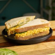 smashed white bean salad sandwich on a black plate