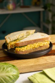 smashed white bean salad sandwich on a black plate