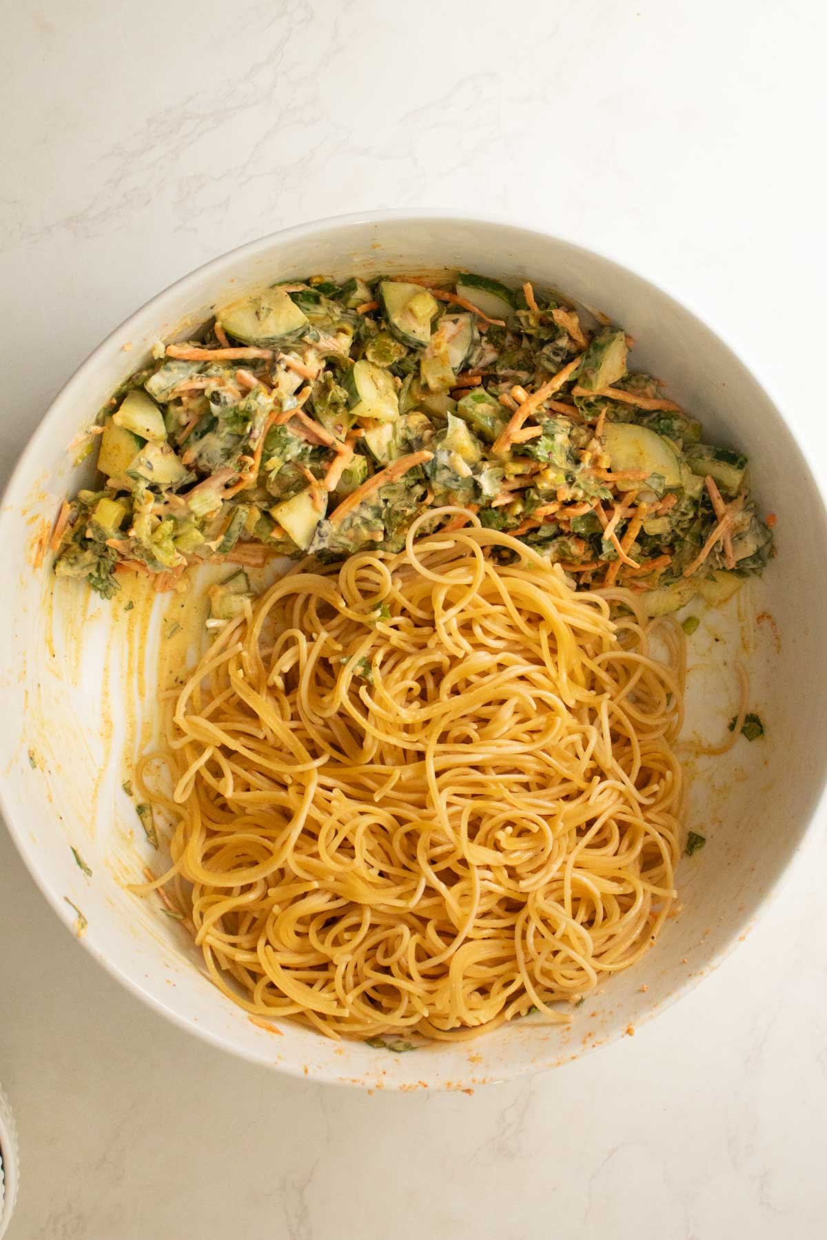 adding noodles to the bowl of curry sauce
