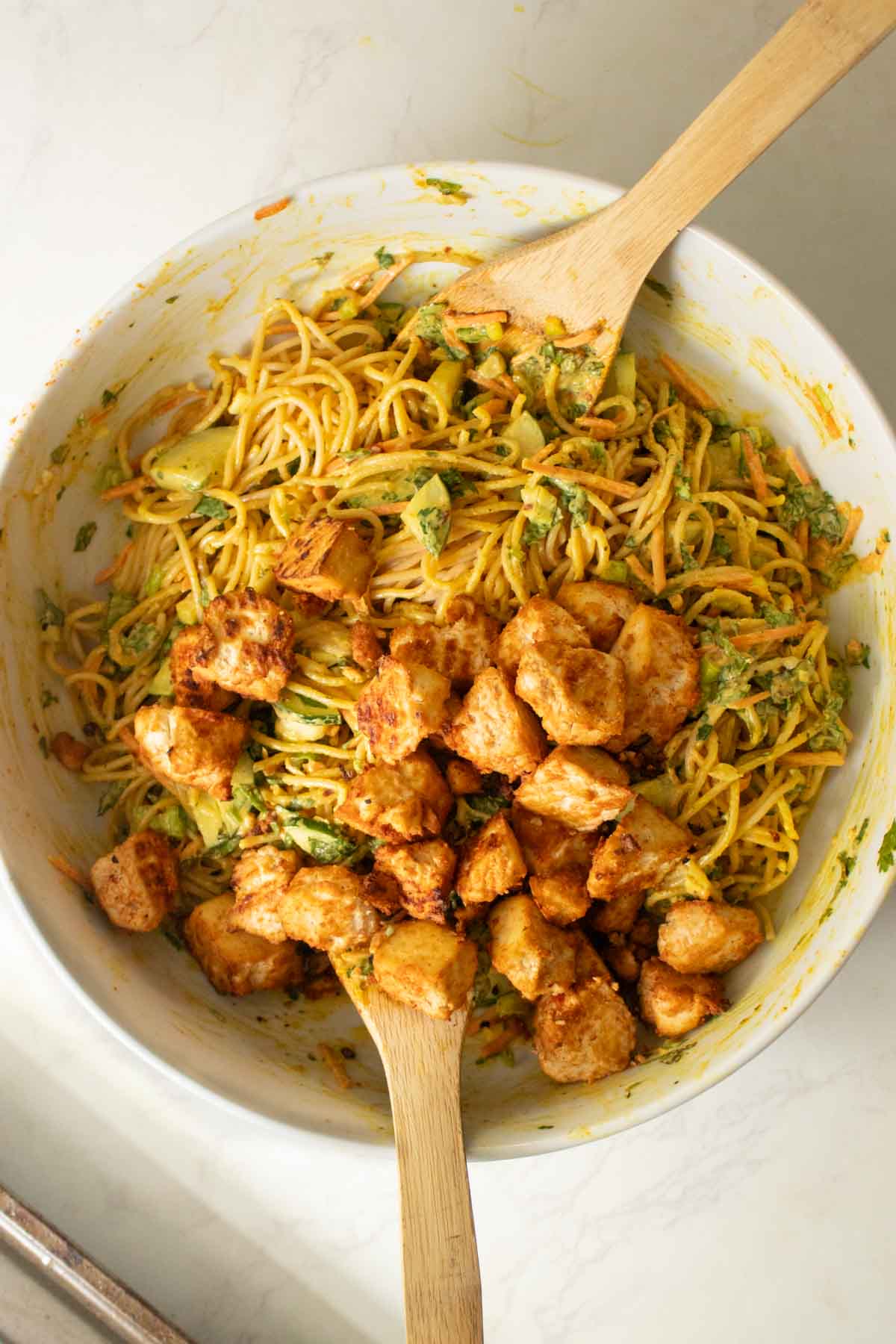 adding tofu to the salad bowl