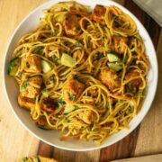 bowl of curry noodle salad on a wooden table