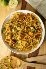 bowl of curry noodle salad on a wooden table