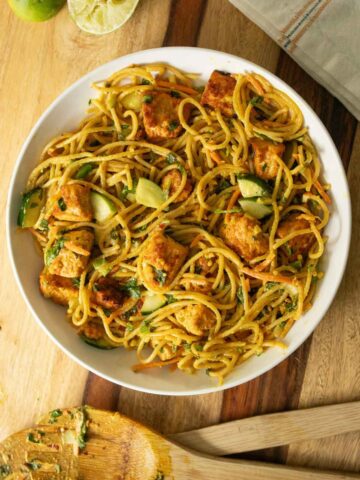 bowl of curry noodle salad on a wooden table