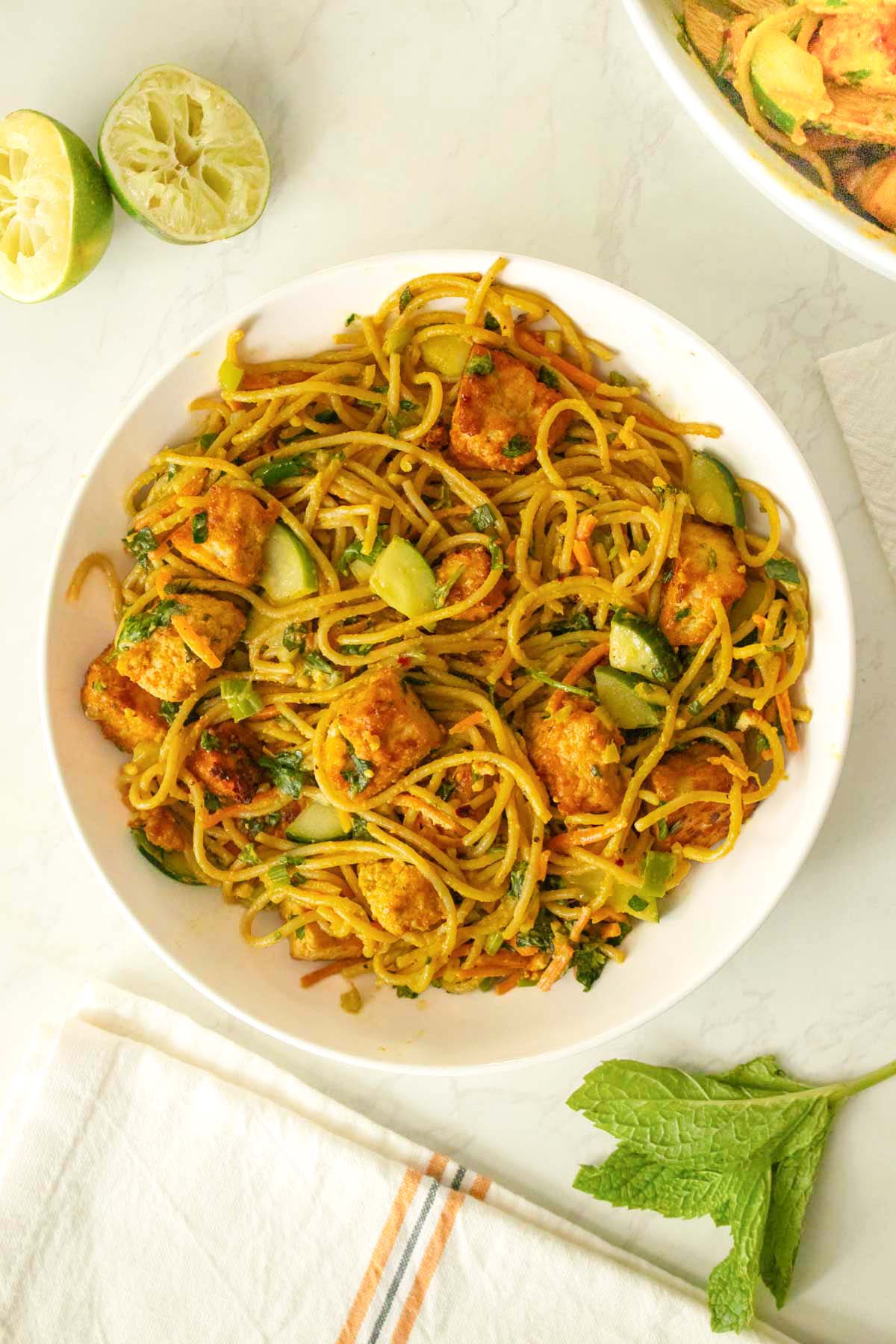 curry noodle salad in a bowl on a white table