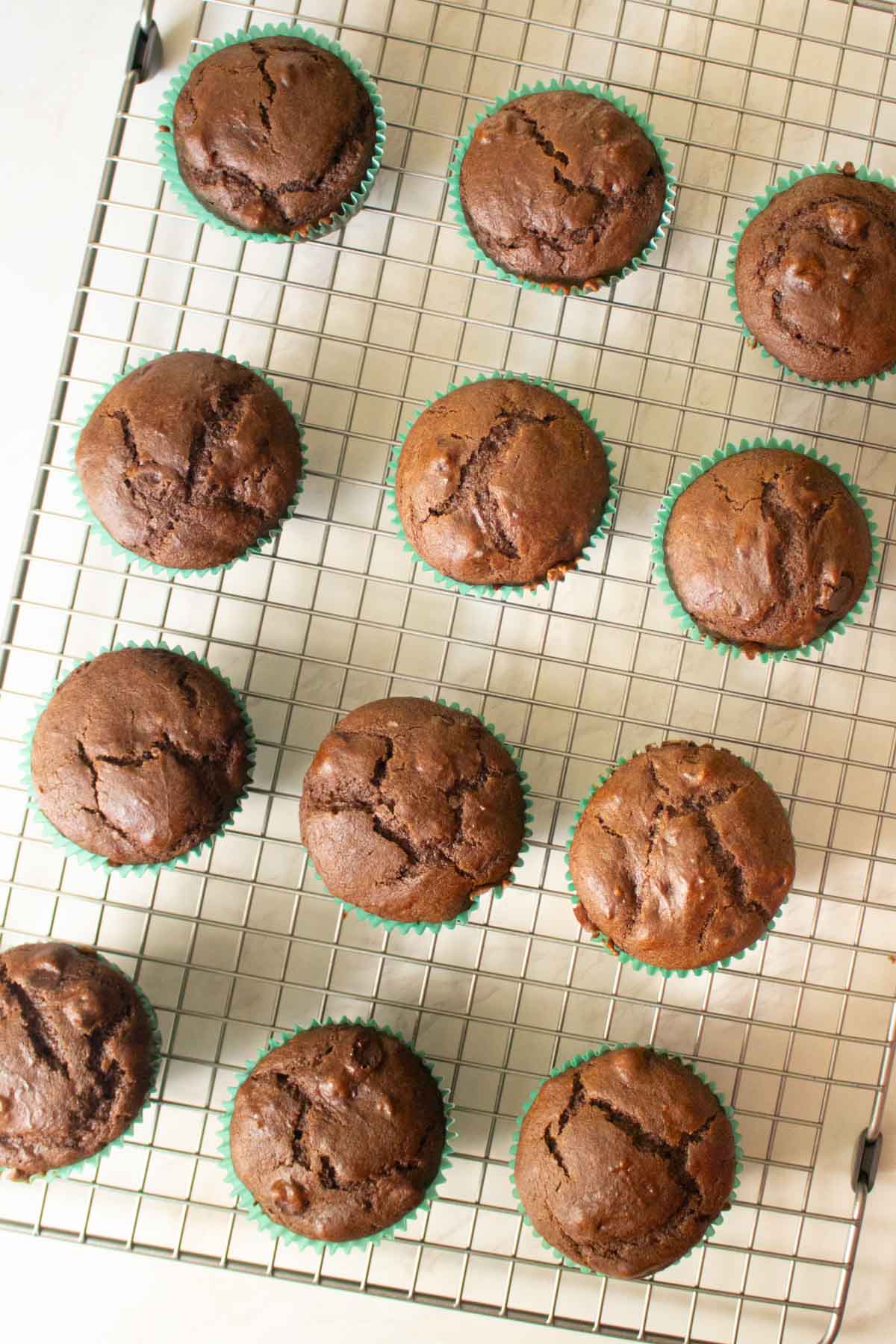 vegan chocolate chocolate chip muffins on a cooling rack