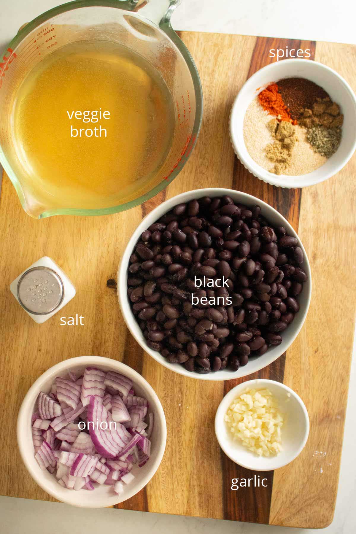smoky black beans ingredients in bowls on a wooden cutting board