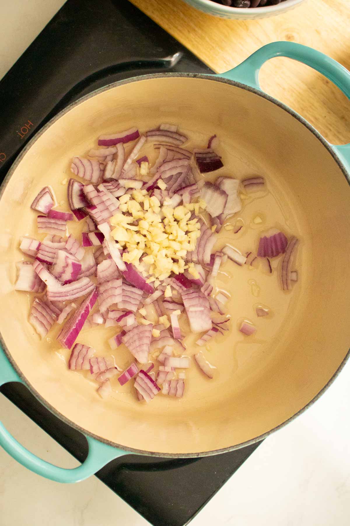 adding onion and garlic to the pan