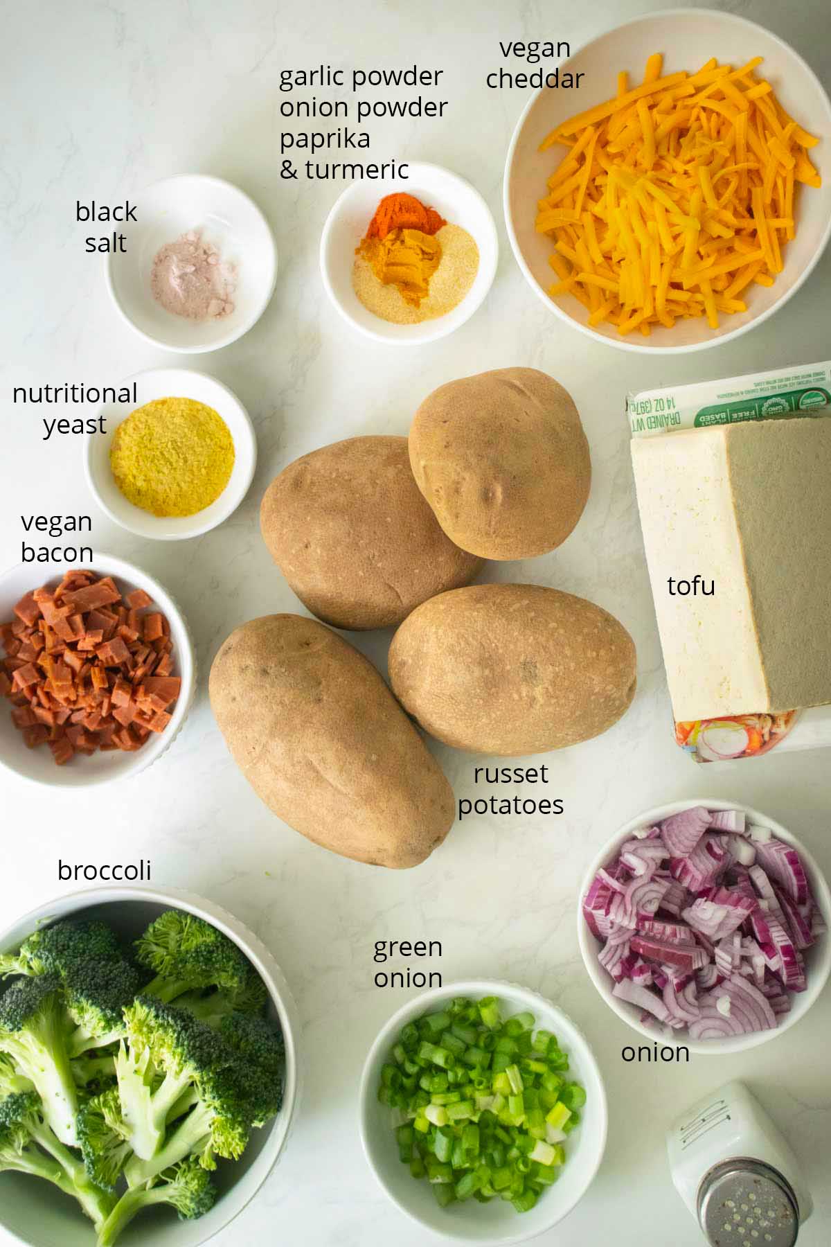 breakfast loaded baked potato ingredients on the kitchen counter, text labels on each one