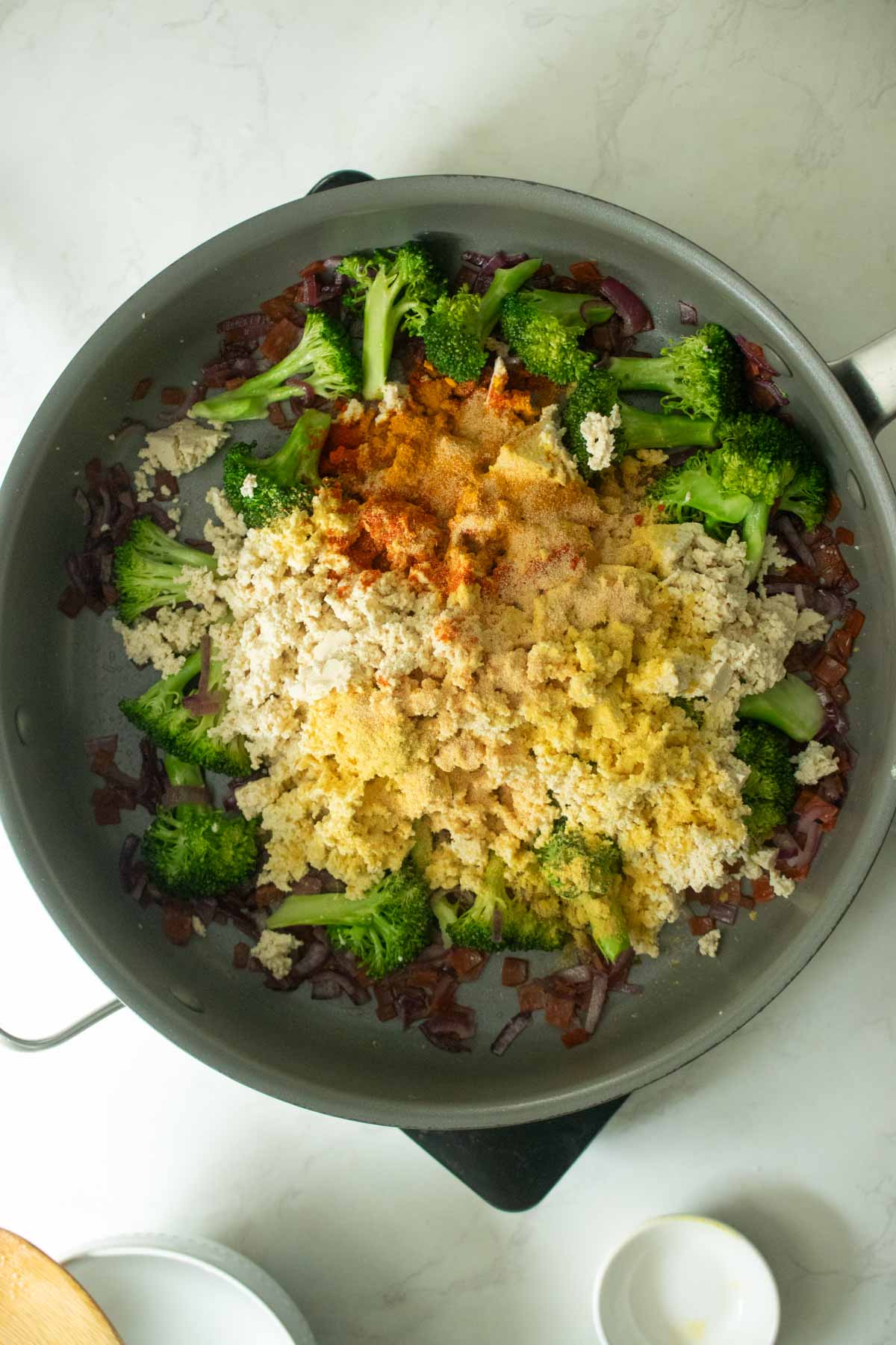 adding nutritional yeast and spices to the pan