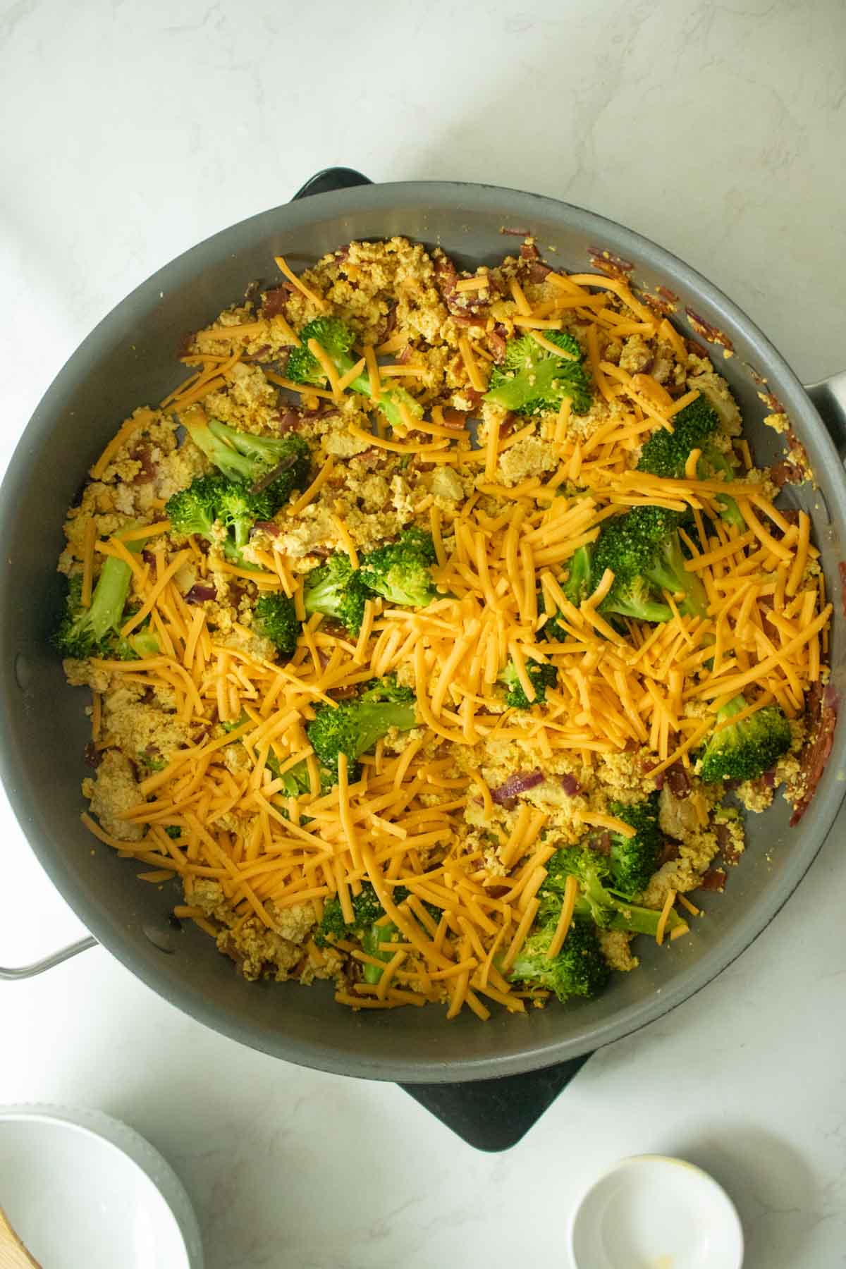 adding vegan cheddar to the pan