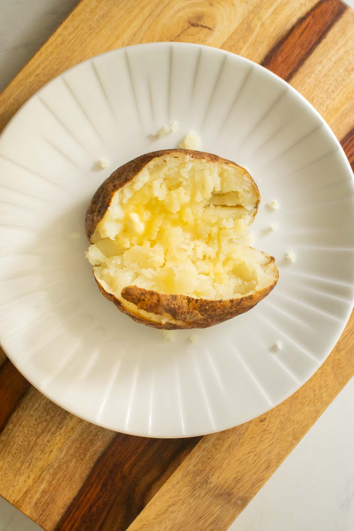 baked potato cut in half with vegan butter