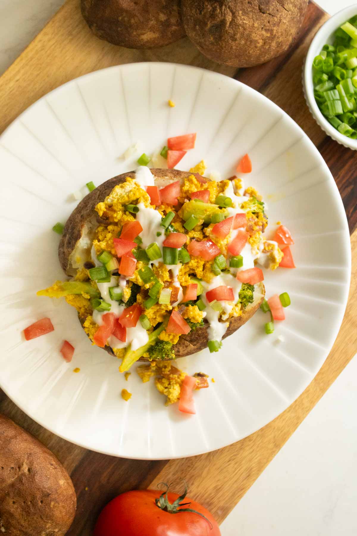 loaded baked breakfast potato on a plate with all the toppings