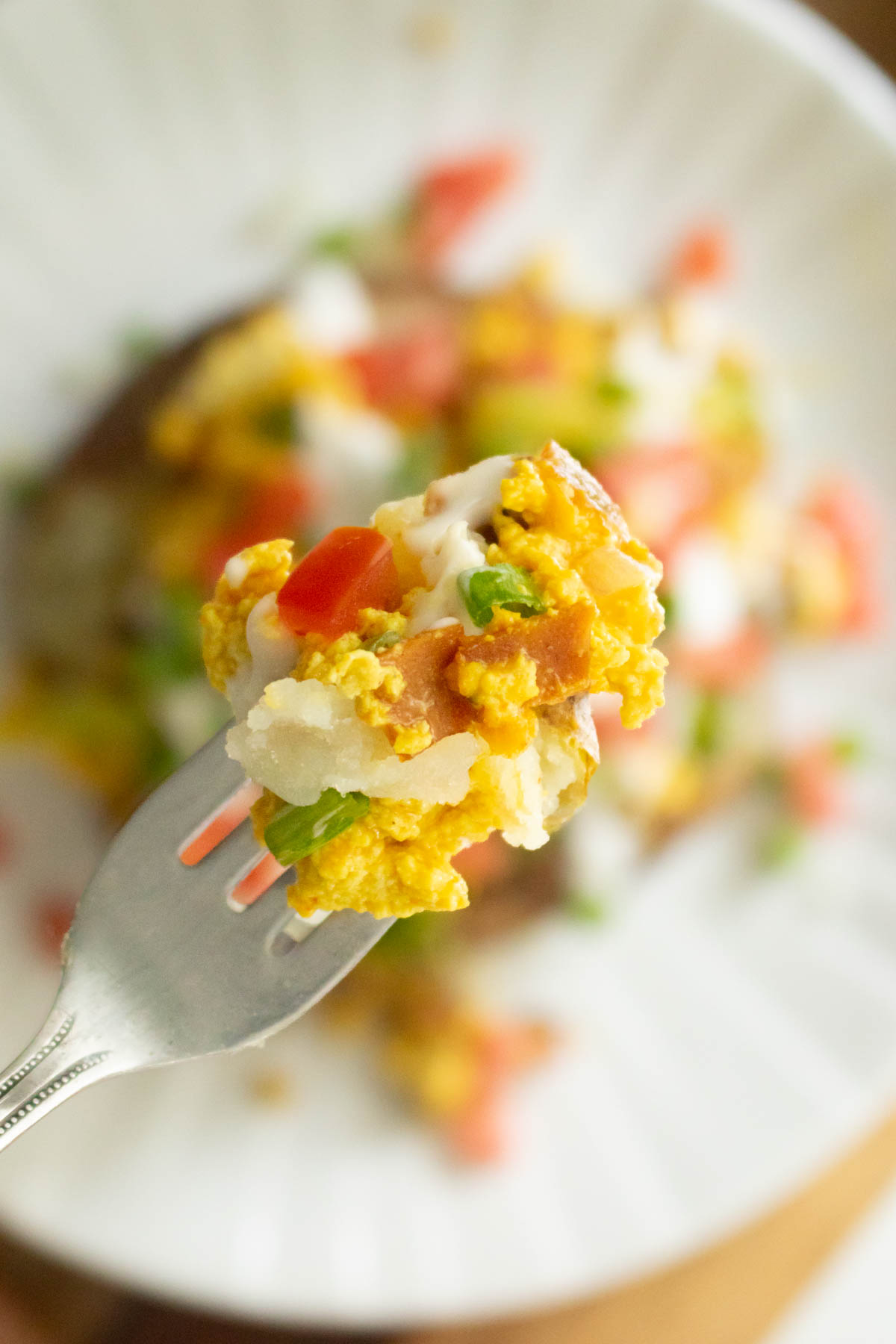 fork taking a bite of breakfast loaded baked potato