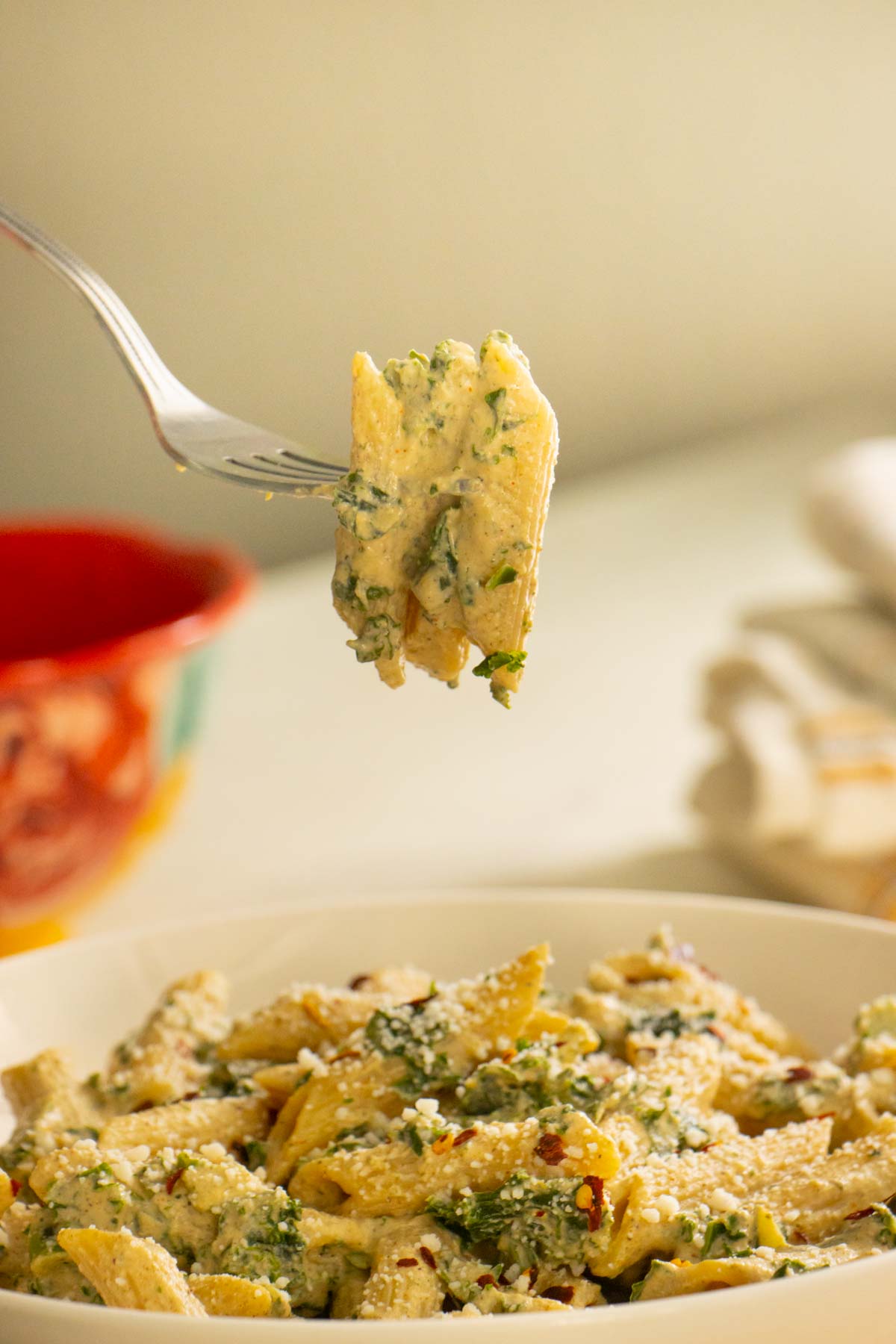 fork taking a bite of vegan white sauce pasta