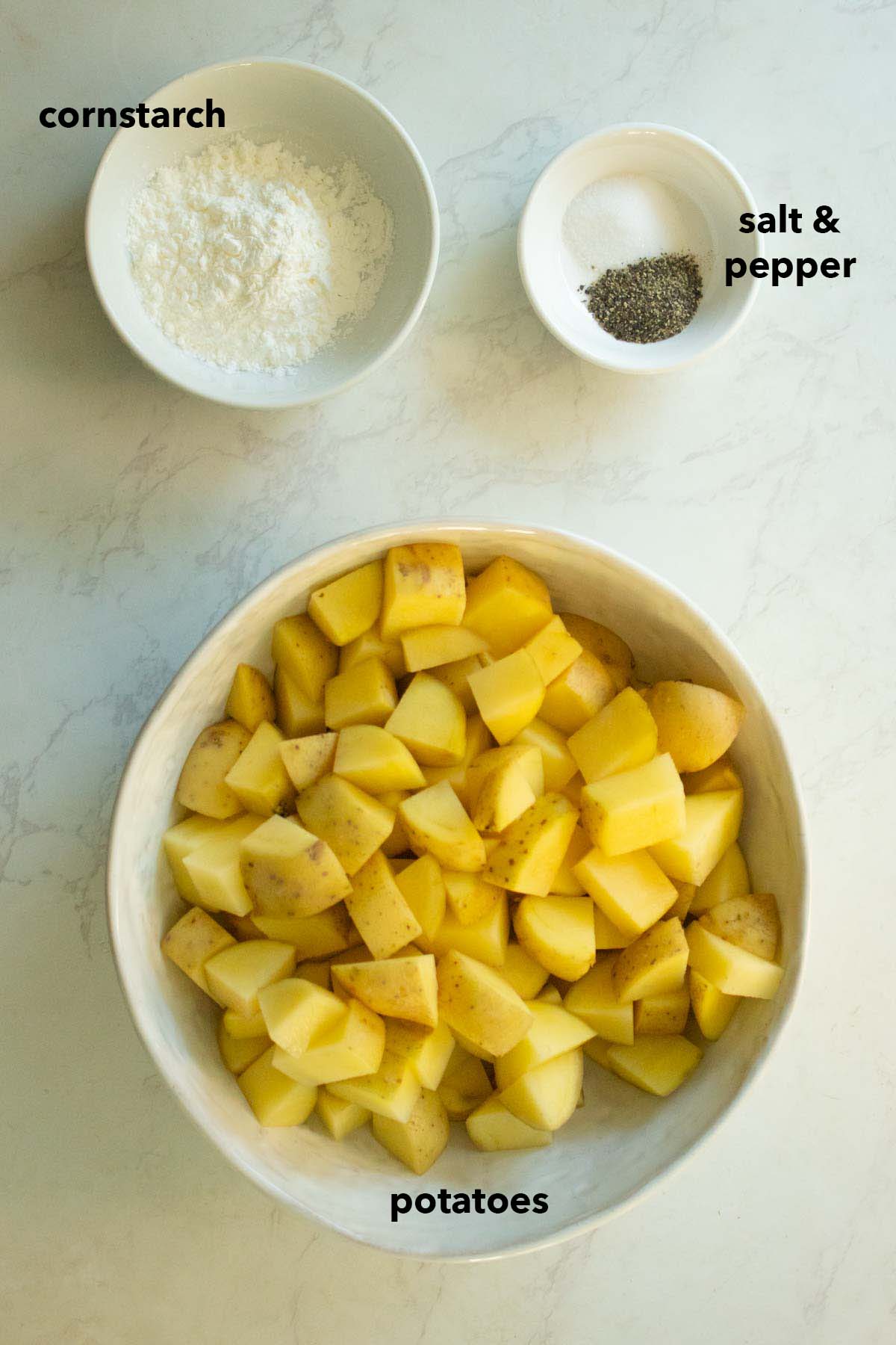 crispy potatoes ingredients in white bowls on the kitchen counter with text labels on each ingredient