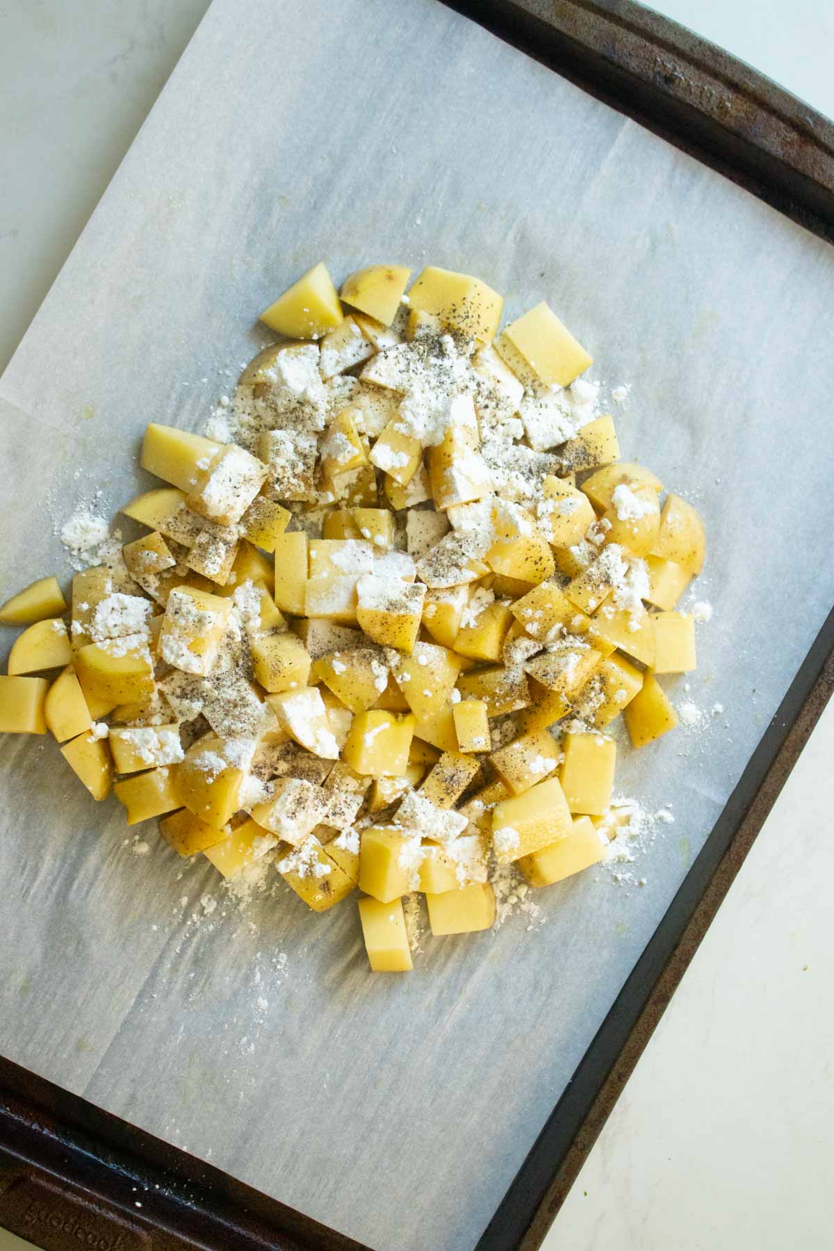 adding cornstarch, salt, and pepper to the potatoes