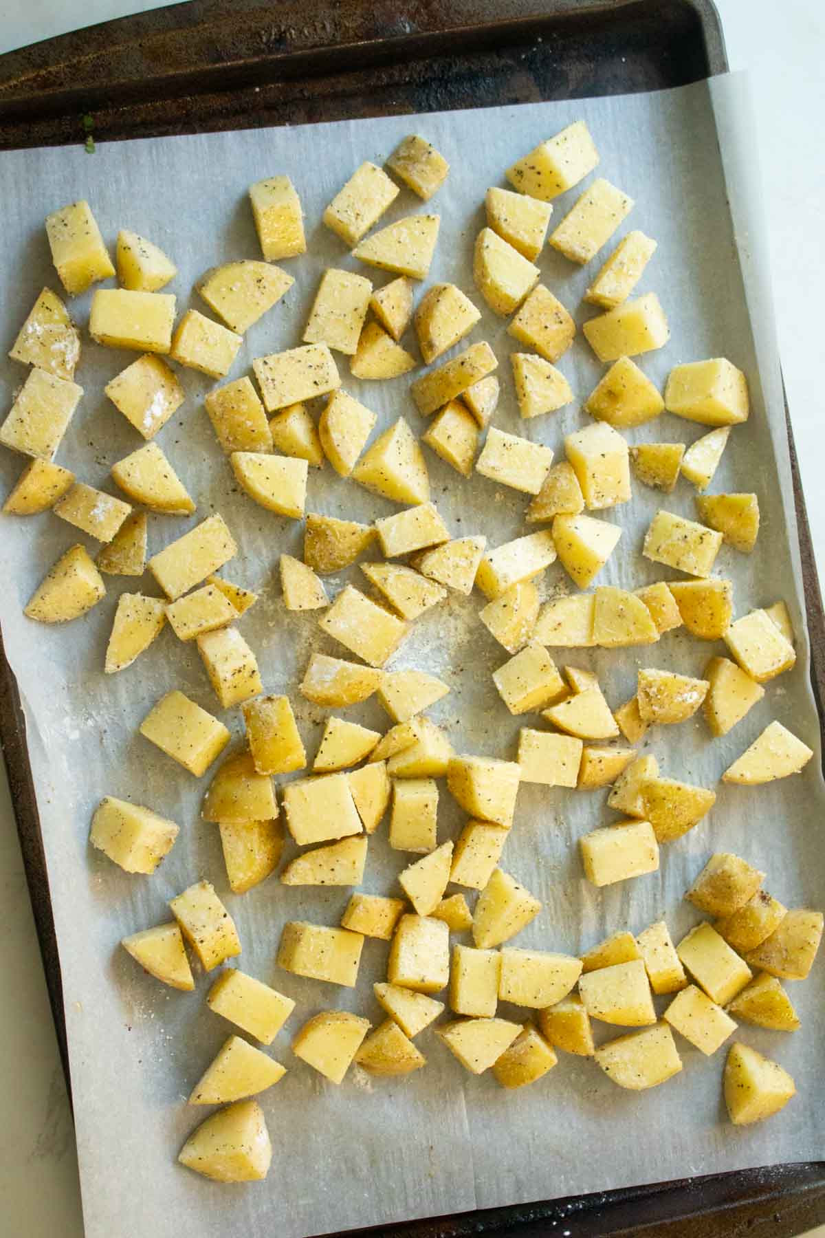 potatoes tossed in cornstarch, salt, and pepper, ready to bake