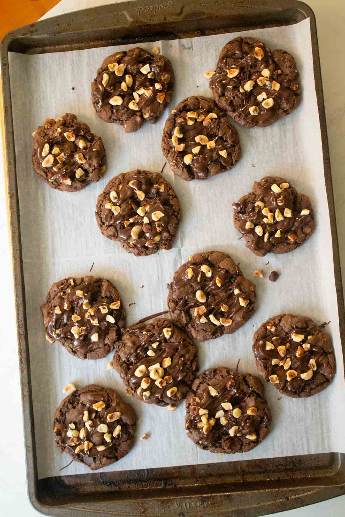 chocolate hazelnut cookies on the baking sheet after sprinkling on hazelnuts