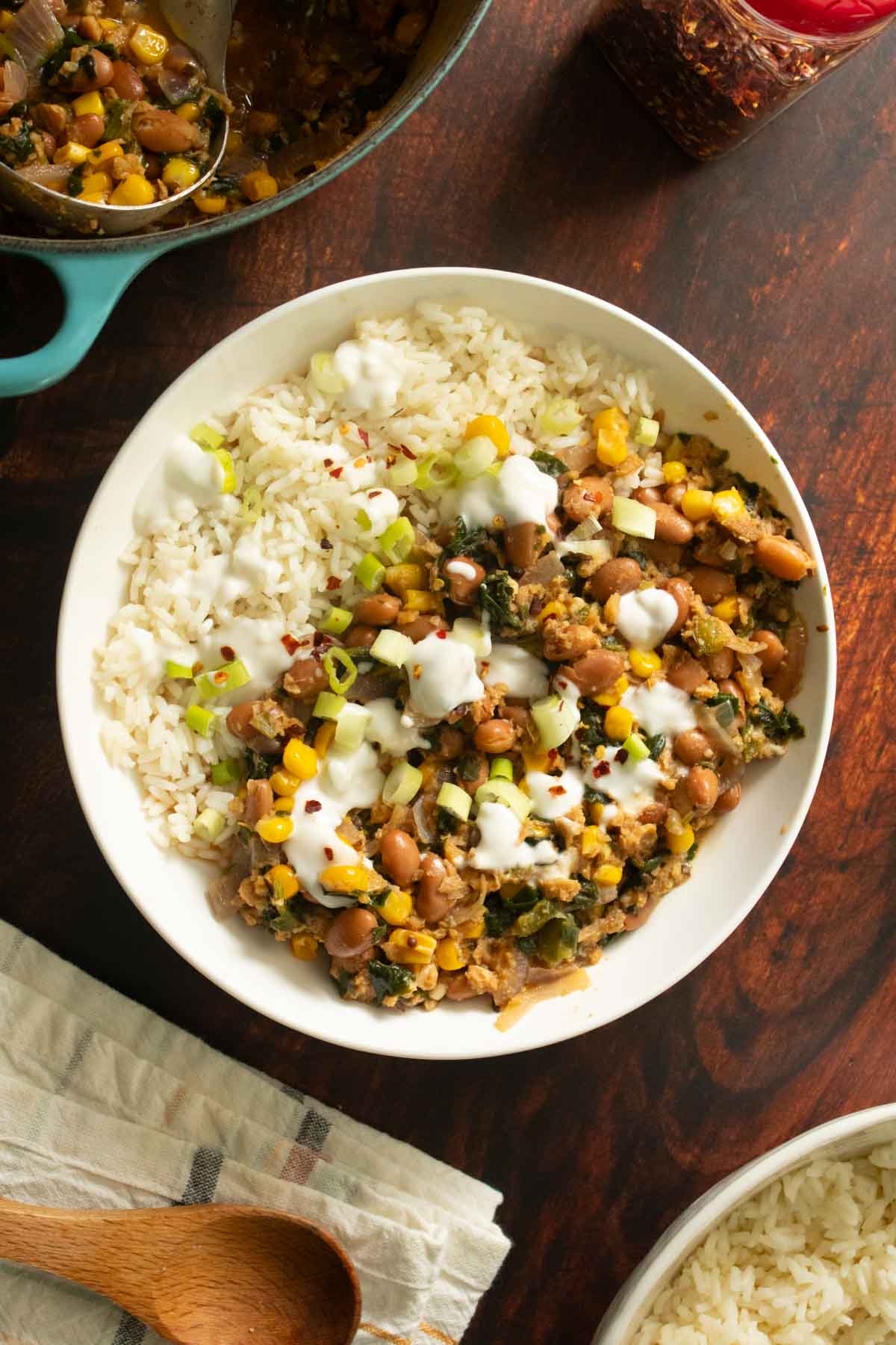 bowl of pinto bean curry next to the serving dishes