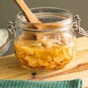 jar of pickled garlic on a wooden cutting board