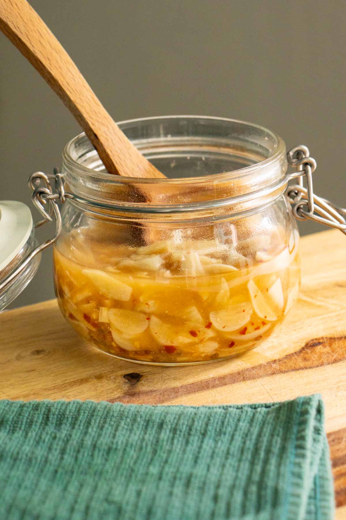 jar of pickled garlic on a wooden cutting board