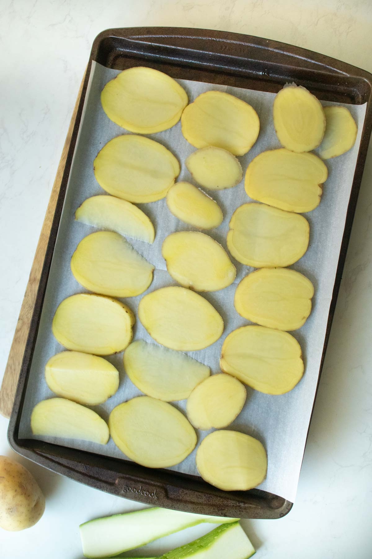 sliced potatoes on the baking sheet before baking