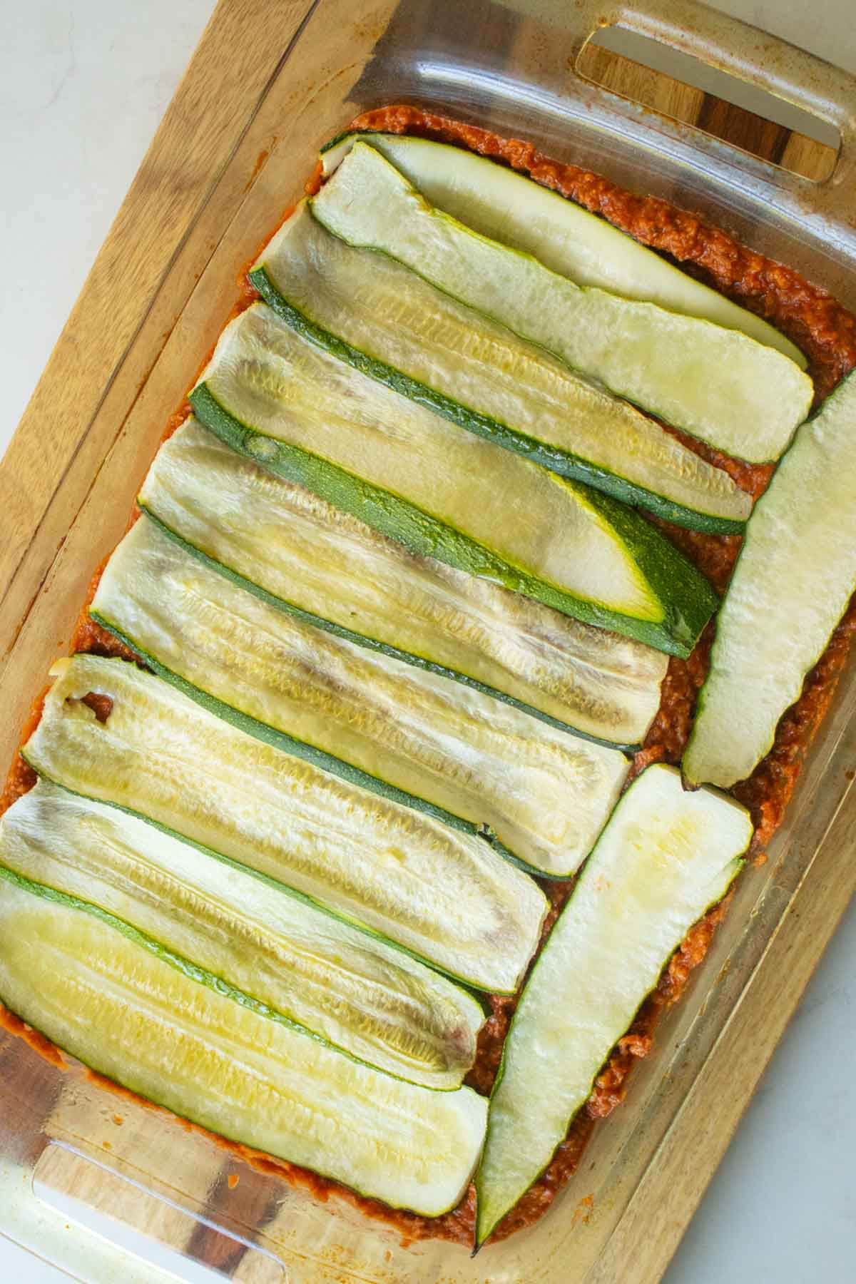 adding the zucchini layer on top of the meat sauce