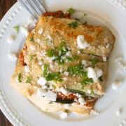 zucchini moussaka on a white plate with a fork