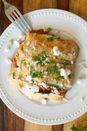 zucchini moussaka on a white plate with a fork