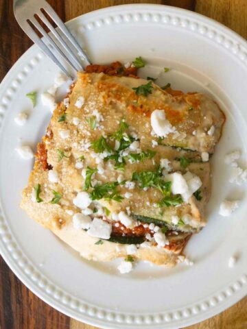 zucchini moussaka on a white plate with a fork
