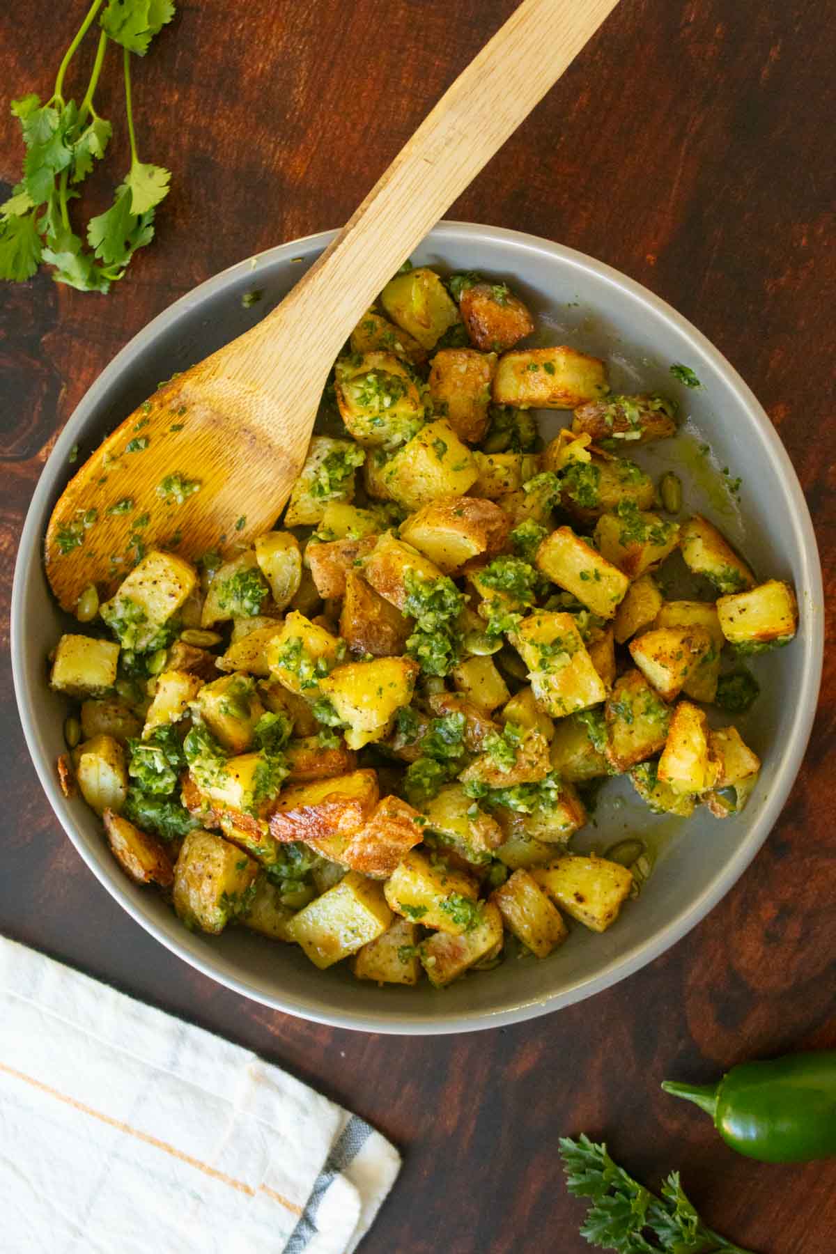 chimichurri potatoes on a serving platter with a spoon