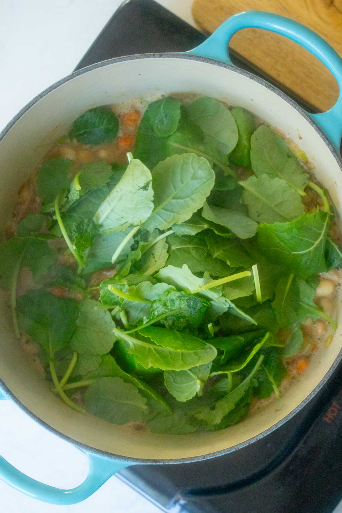 adding baby kale to the pot