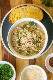 lemon white bean soup in a bowl with garnishes and a slice of bread