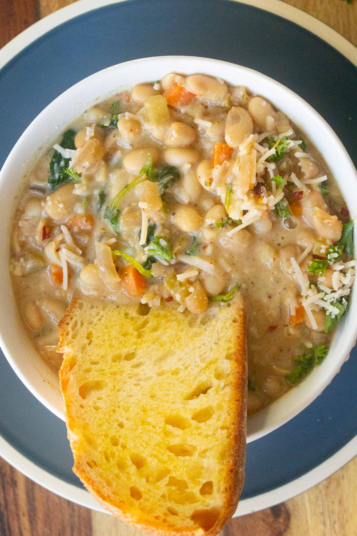 bowl of lemon white bean soup with bread dipped into it