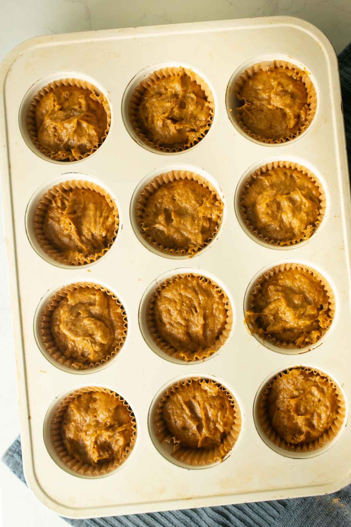 pumpkin banana bread muffins in the baking pan before adding toppings and baking