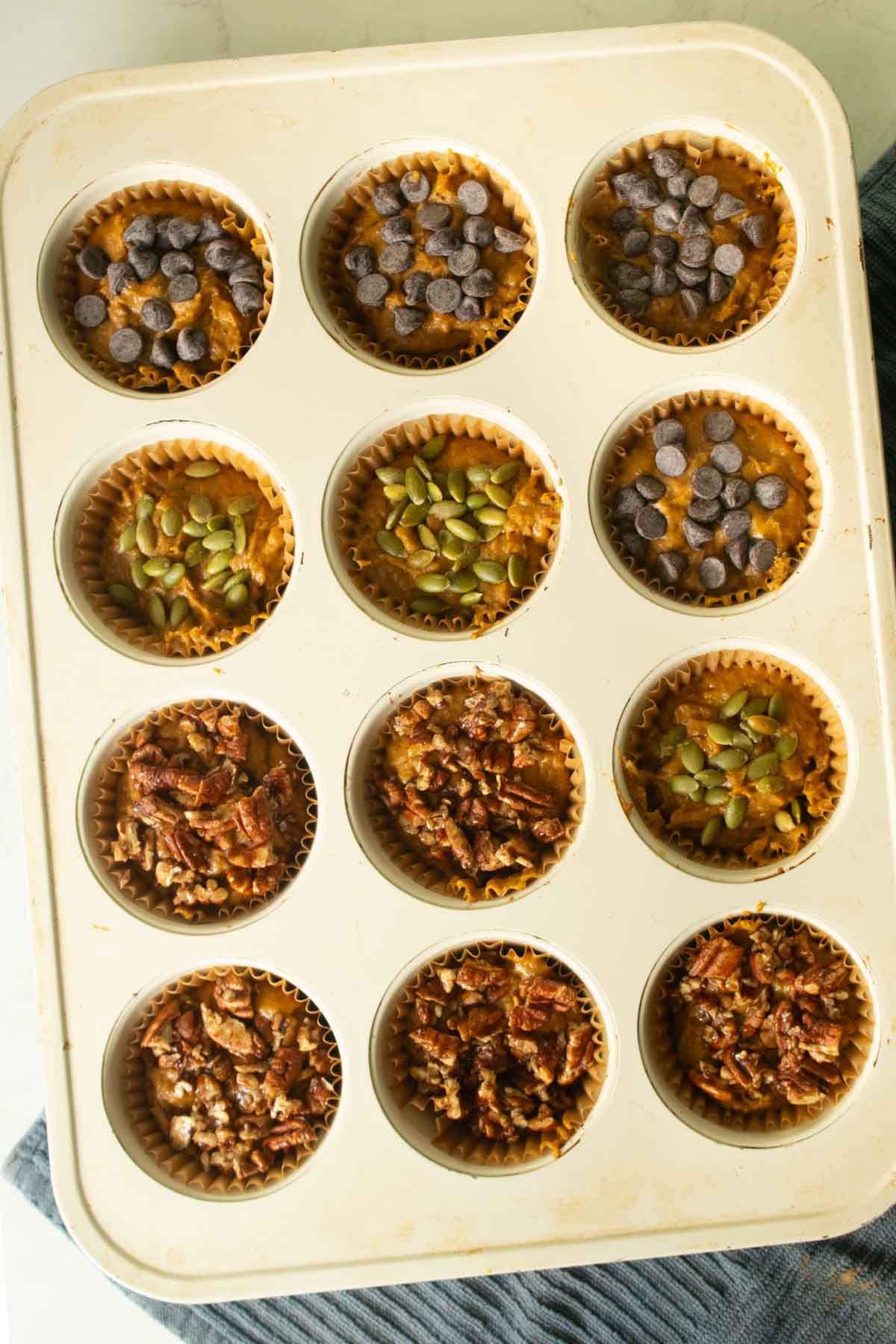 pumpkin banana bread muffins in the baking pan after adding toppings