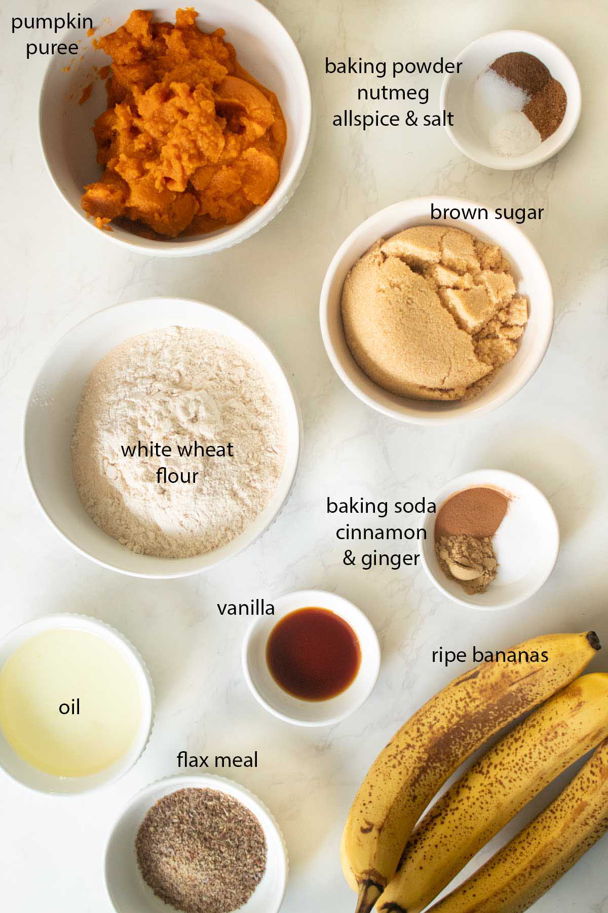 pumpkin banana bread muffin ingredients in bowls on the kitchen counter, text labels on each one