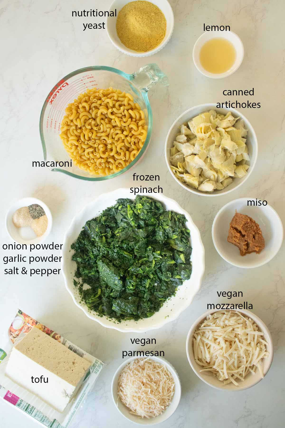 spinach artichoke mac and cheese ingredients in bowls on the kitchen counter