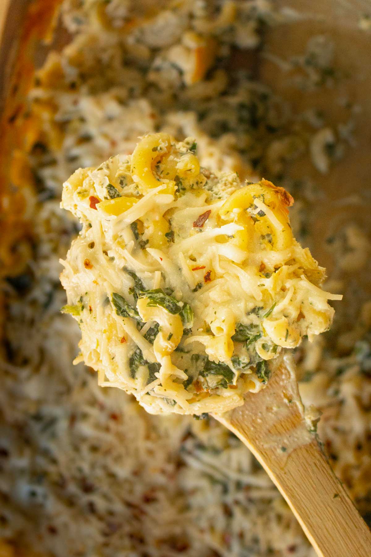 spoon serving spinach artichoke mac and cheese