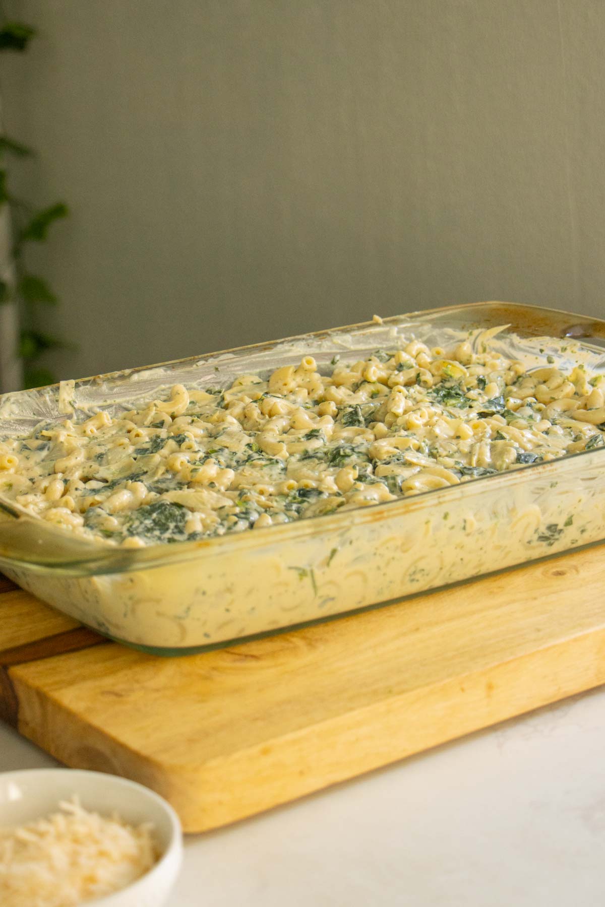 spinach artichoke mac and cheese in the pan before adding cheese topping