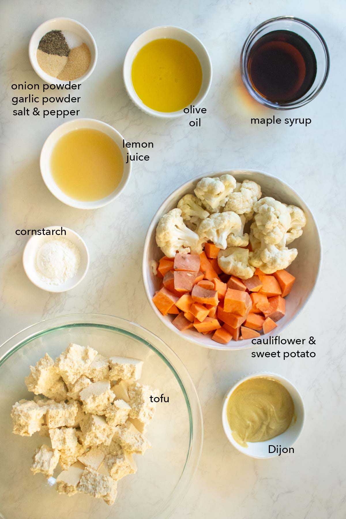 sheet pan tofu dinner ingredients in bowls on a white table