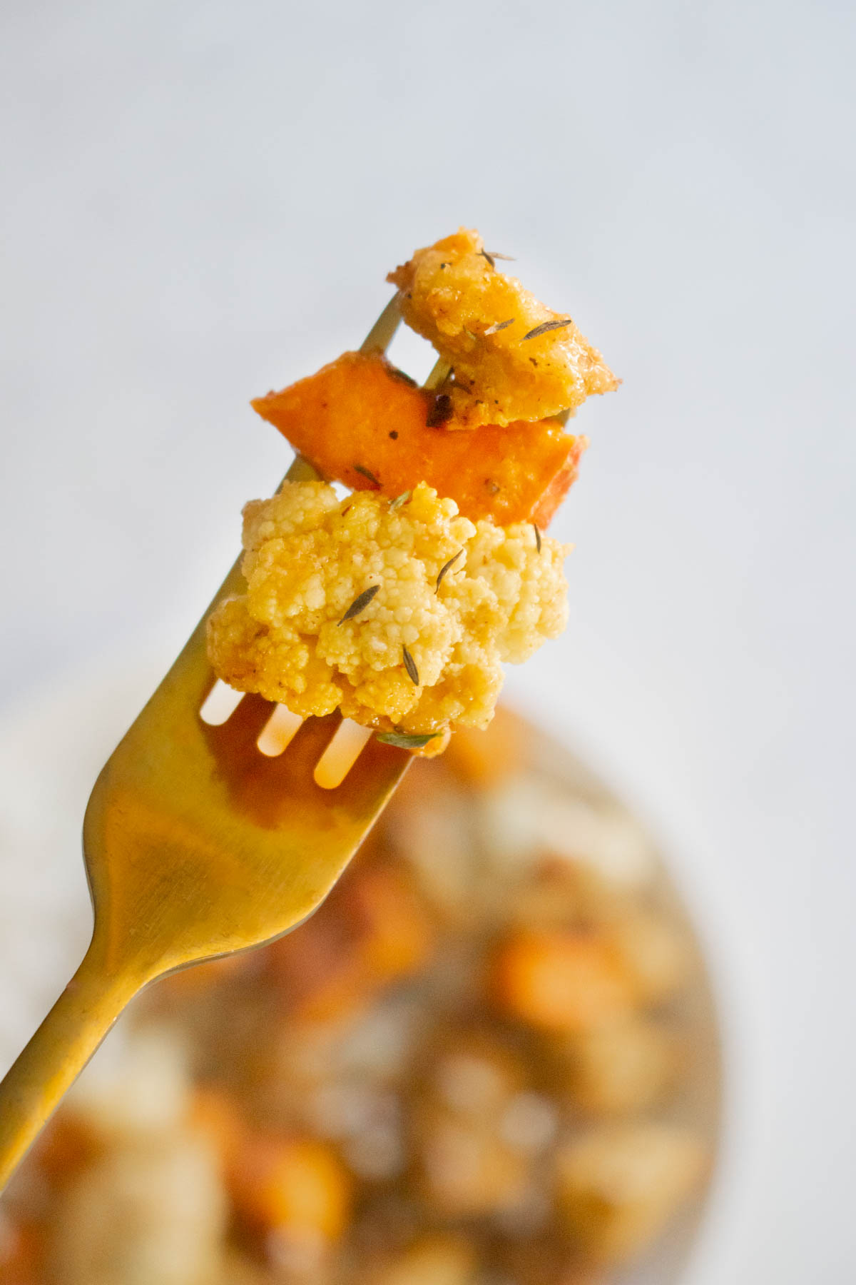 fork with a bite of cauliflower, sweet potato, and tofu
